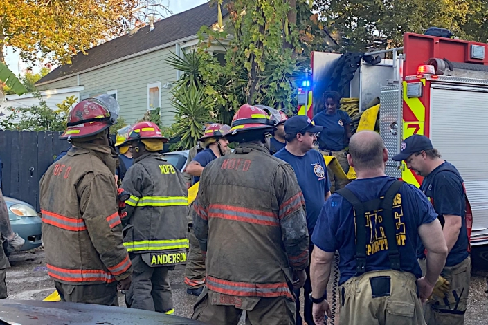 House Damaged by Fire in the Bywater. Emergency Crews on the Scene.